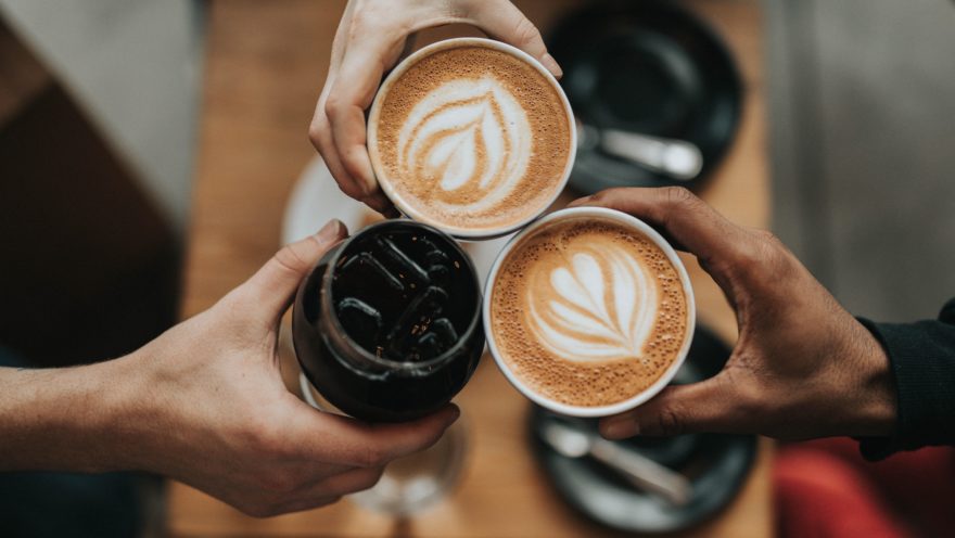 coffee Three hands holding coffee cups touching