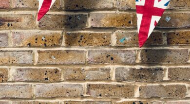 Union Jack flag bunting against a brown brick wall