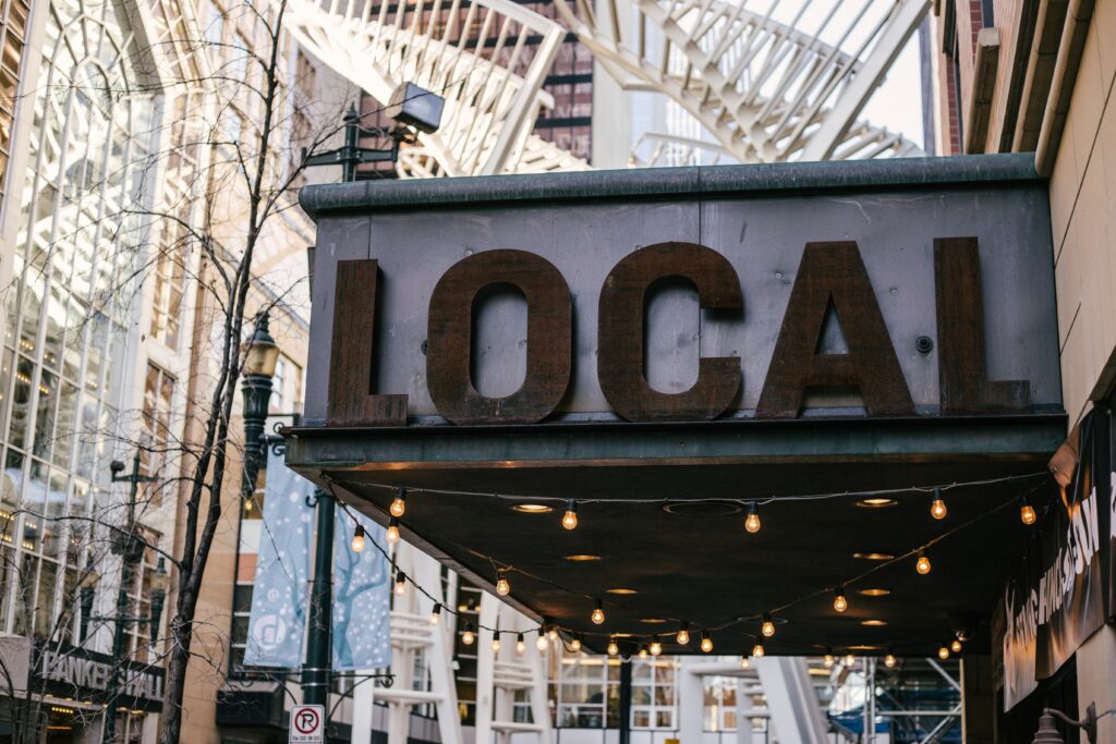 Close up photo shows large shop sign reading 'LOCAL' in capital letters