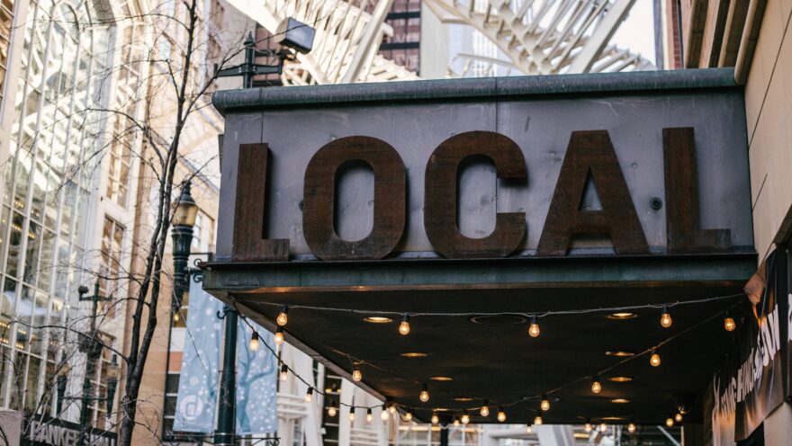 Close up photo shows large shop sign reading 'LOCAL' in capital letters